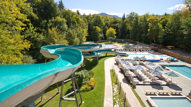 A water park with multiple slides and a pool area with lounge chairs and umbrellas. - Club Wyndham Smugglers’ Notch Vermont  (Jeffersonville)