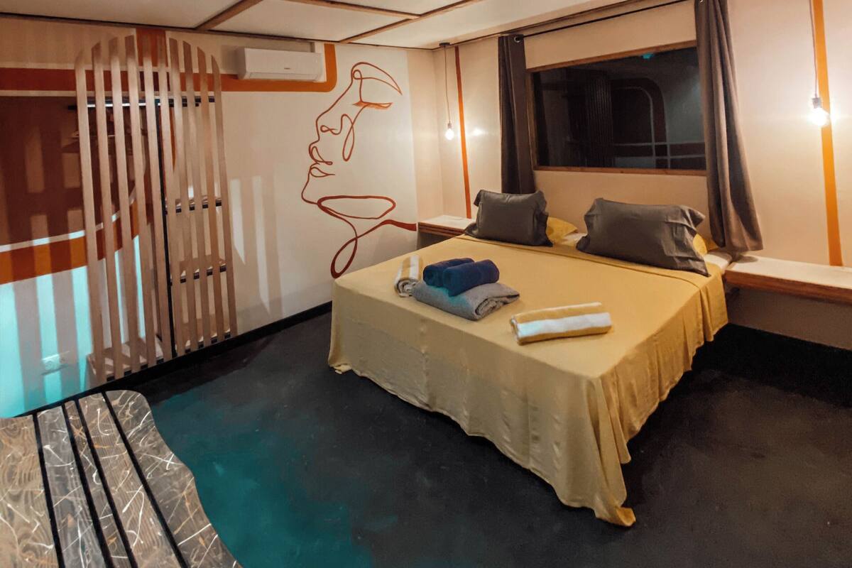 Habitación de hotel moderna con cama, escritorio y vista al exterior.