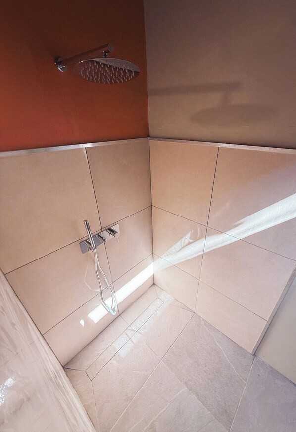 A bathroom with a shower, tiled walls, and a visible pipe. - Villa Mitirapa (Taiarapu-Ouest)