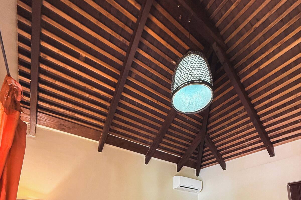 Una habitación con dos camas, ventilador de techo y aire acondicionado.
