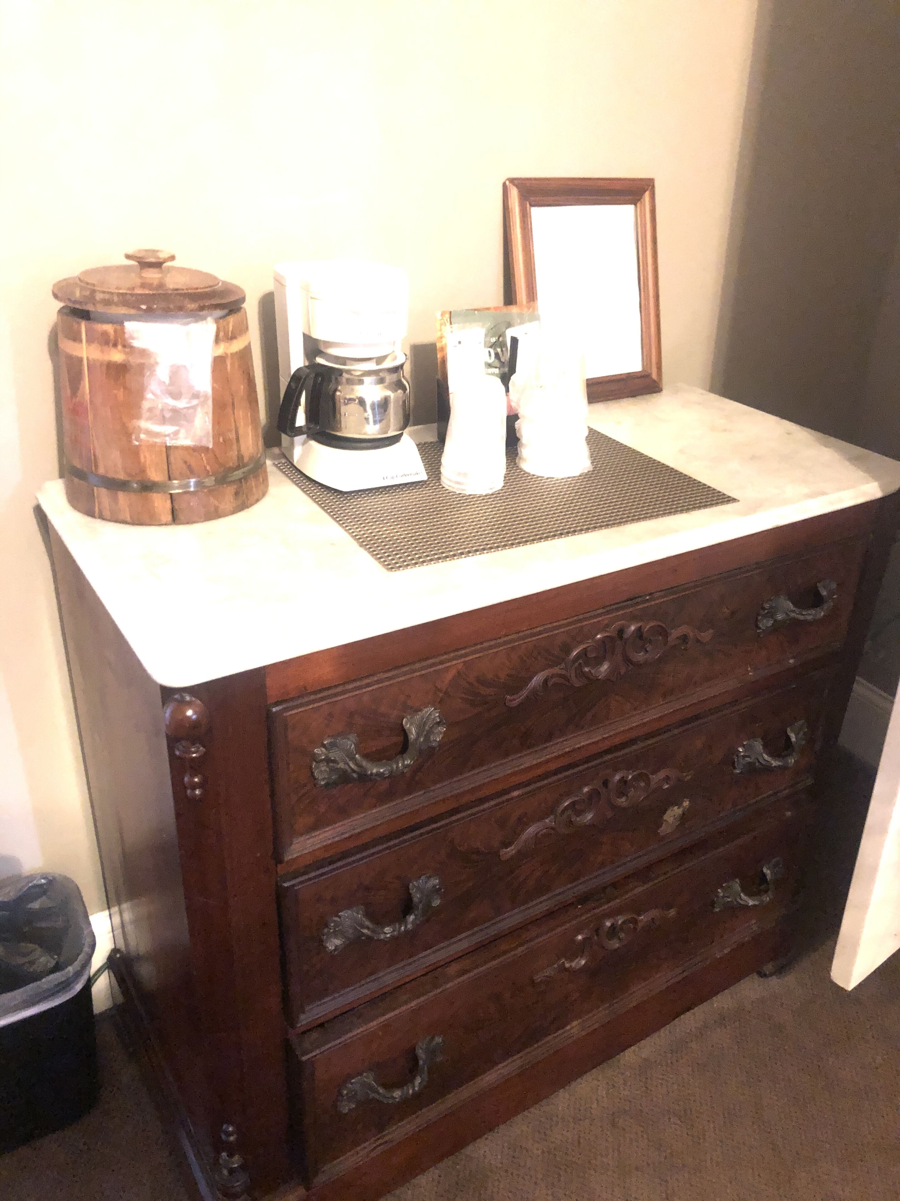 A wooden dresser with drawers and a marble countertop.