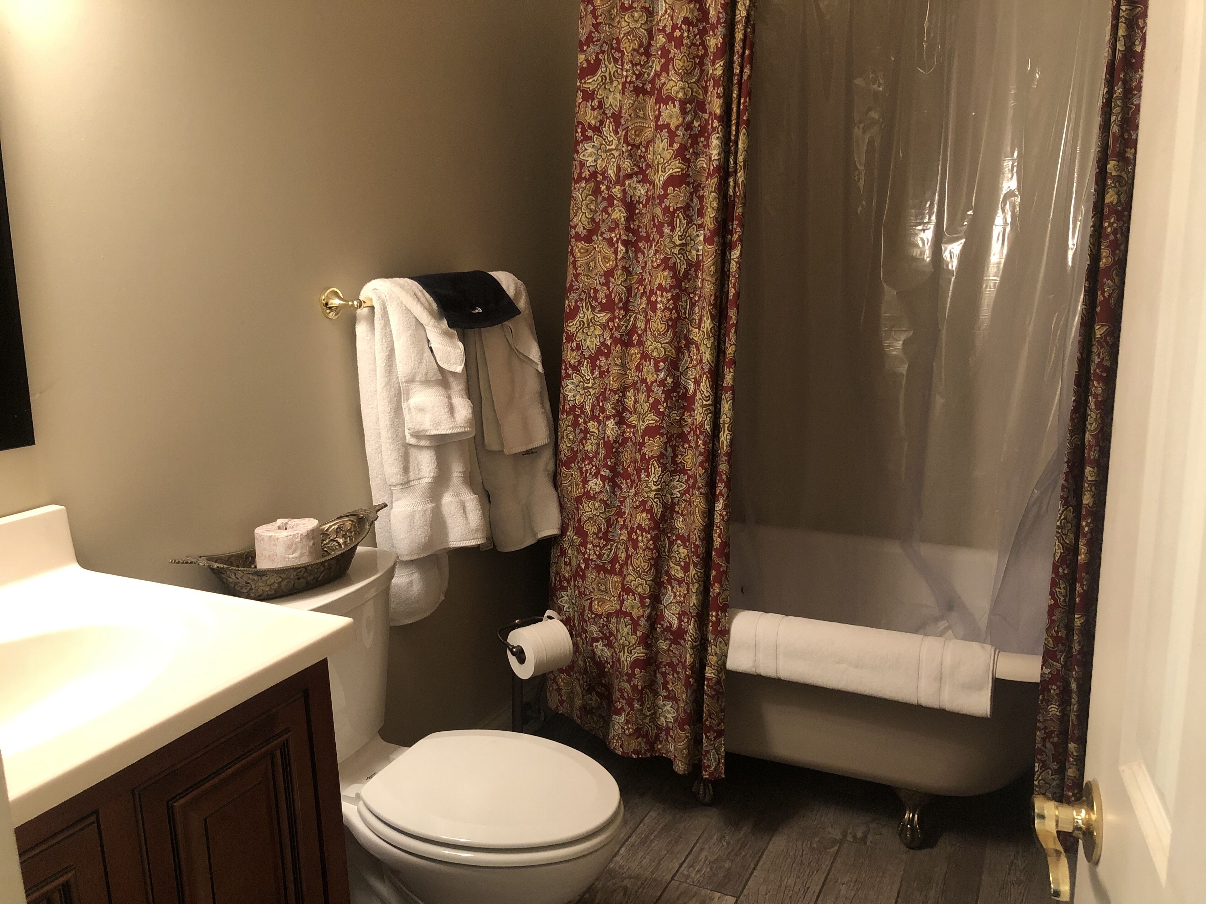 A bathroom with a toilet, a sink, a bathtub, and a shower curtain.