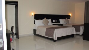 Una habitación de hotel con una cama grande, una mesita de noche y una lámpara de pared.