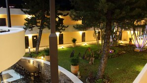 Un patio con zona de comedor, suelo de piedra y plantas en macetas.