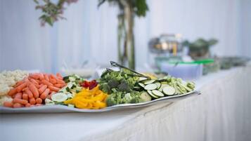Una mesa de buffet con diversas verduras y frutas.
