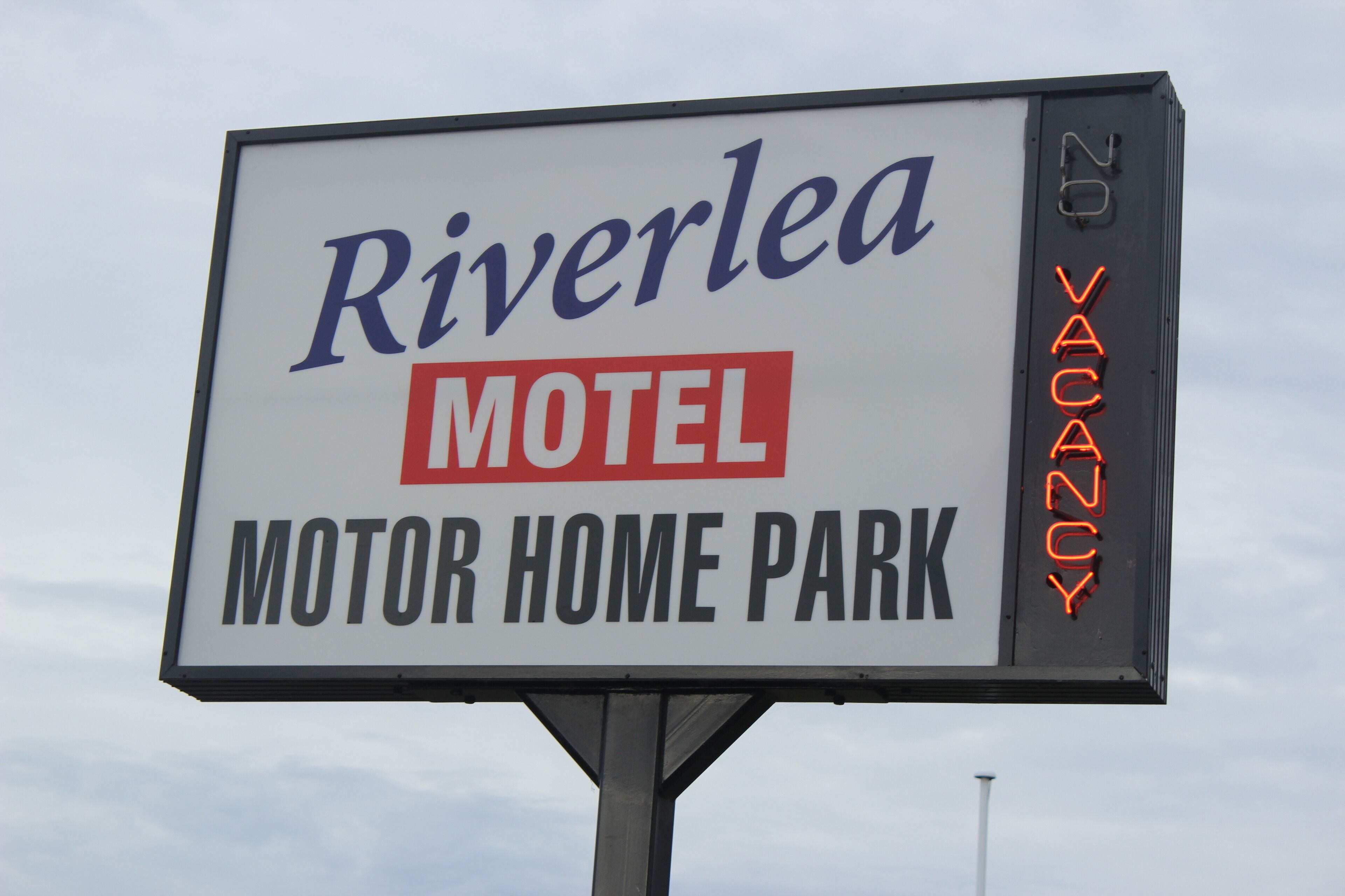 Un letrero de motel con el nombre 'Riverlea Motel' y un letrero que indica 'No hay habitaciones disponibles'.