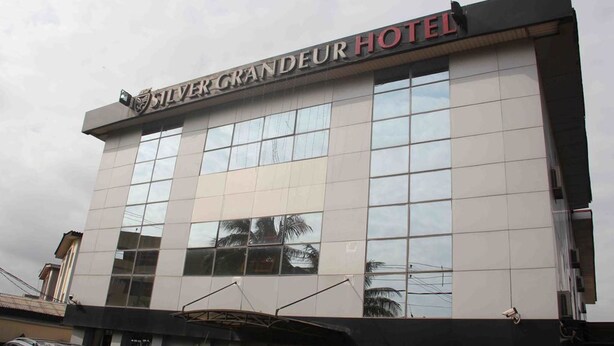 Un edificio de hotel con fachada moderna, ventanas amplias y un letrero que dice "Silver Grandeur Hotel".