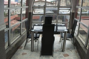 Ein Zimmer mit großem Fenster, einem Tisch und vier Stühlen.