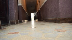 A corridor with a tiled floor and walls. - Wazobia Plaza Hotel (Lagos)