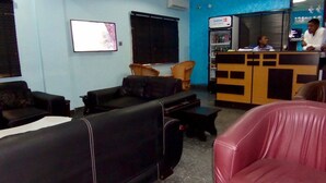 A lobby with black leather sofas, a reception desk, and a blue wall. - Blue Seasons Hotel & Suites (Lagos)