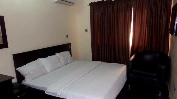 A hotel room with a single bed, a chair, and a TV. - Blue Seasons Hotel & Suites (Lagos)