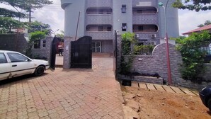 Un edificio moderno con fachada de ladrillo, entrada porticada y camino de acceso pavimentado.