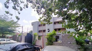 Un edificio de varios pisos con fachada de ladrillo, entrada con portón y un letrero que indica que es un hotel.