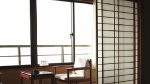 A traditional Japanese room with tatami flooring, a low table, and a sliding shoji screen. - Ryokan Kaiyutei (Nishio)