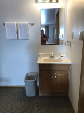 Bañera con ducha, toallas, jabón, shampoo