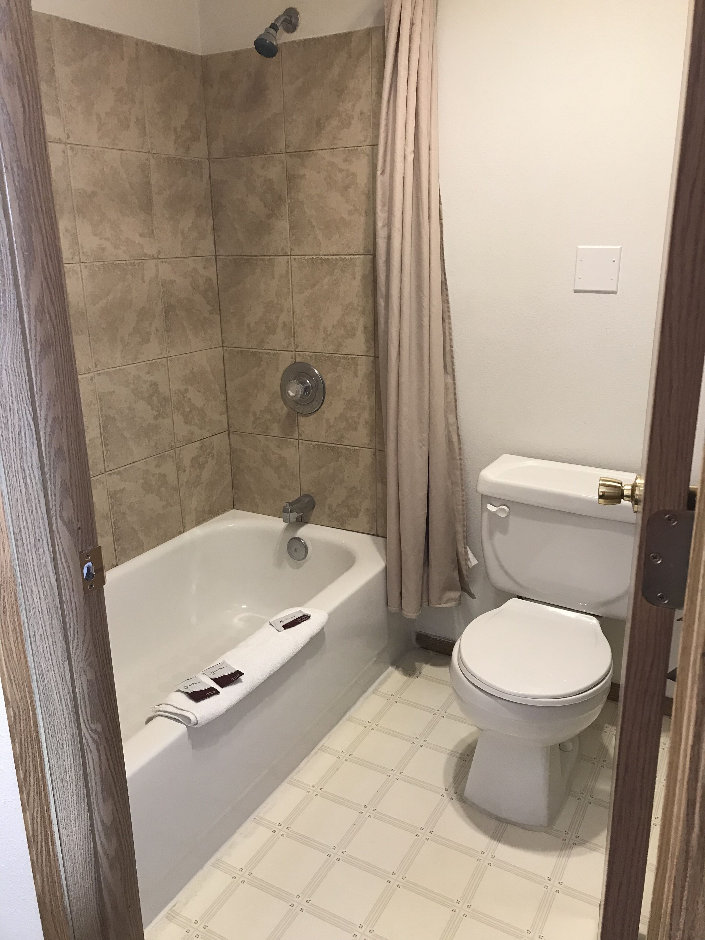 Bañera con ducha, toallas, jabón, shampoo