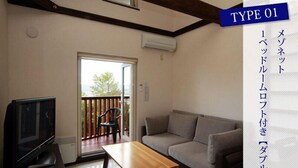 A living room with a sofa, a TV, and a table. There is a sliding door leading to a balcony. - Chalet Fuyuri (Furano)