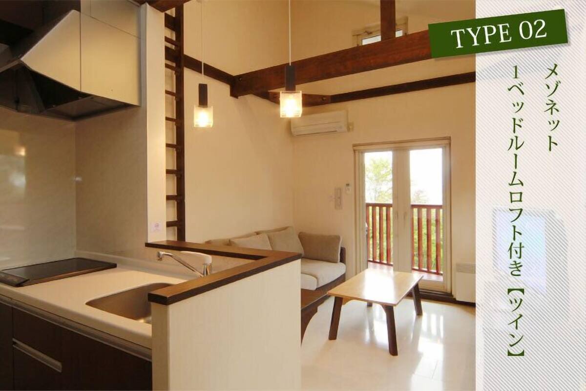 A modern kitchen with a built-in island, wooden beams, and pendant lighting.
