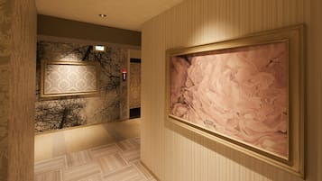 A hallway with patterned wallpaper, a framed artwork, and a patterned floor.