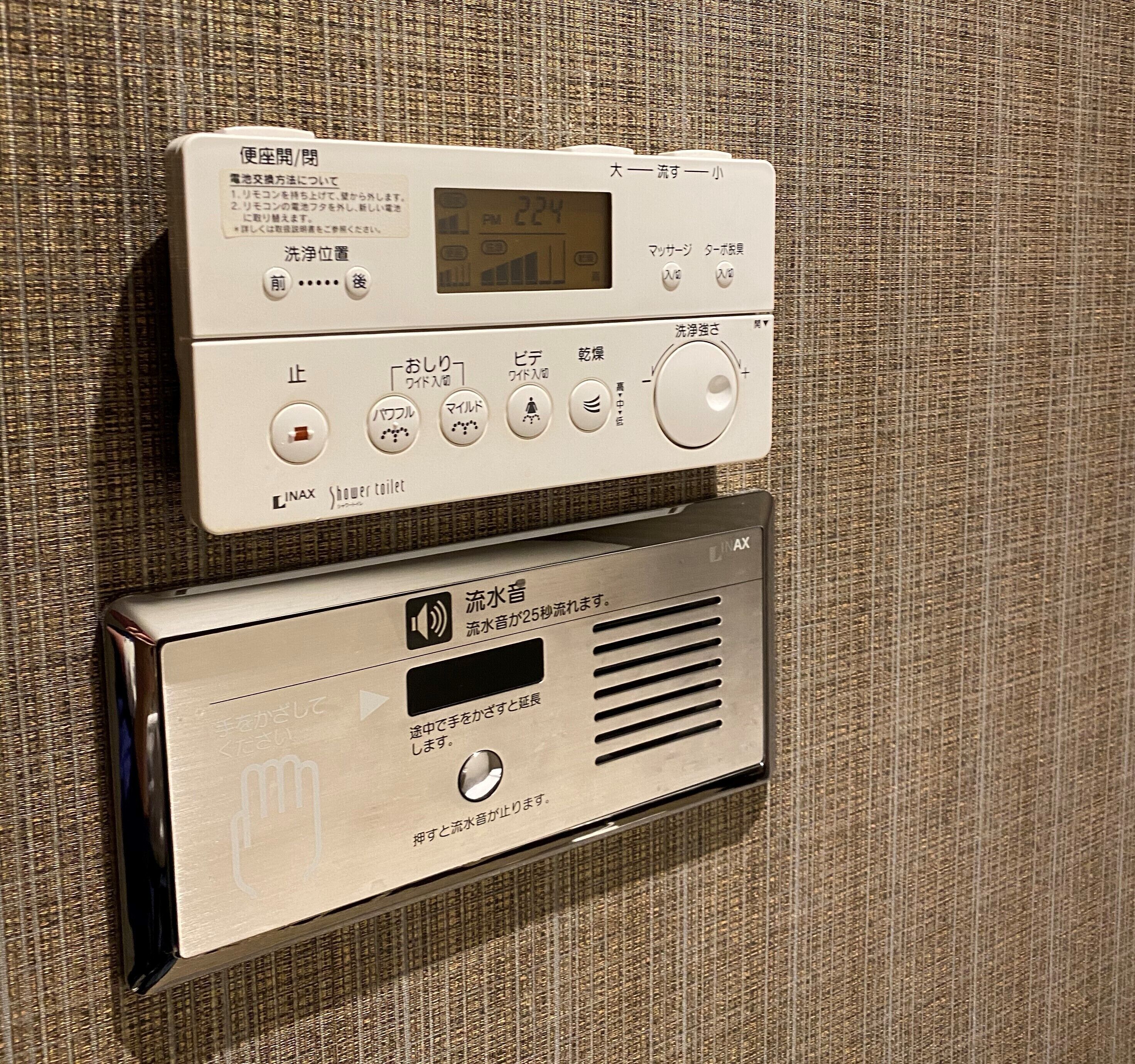 A control panel with a digital display and various buttons for operating a shower system.