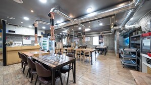 Un restaurante moderno con conductos a la vista, mesas y sillas de madera.