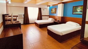 Une chambre d’hôtel avec deux lits, un bureau, une chaise, une télévision et une salle de bain.