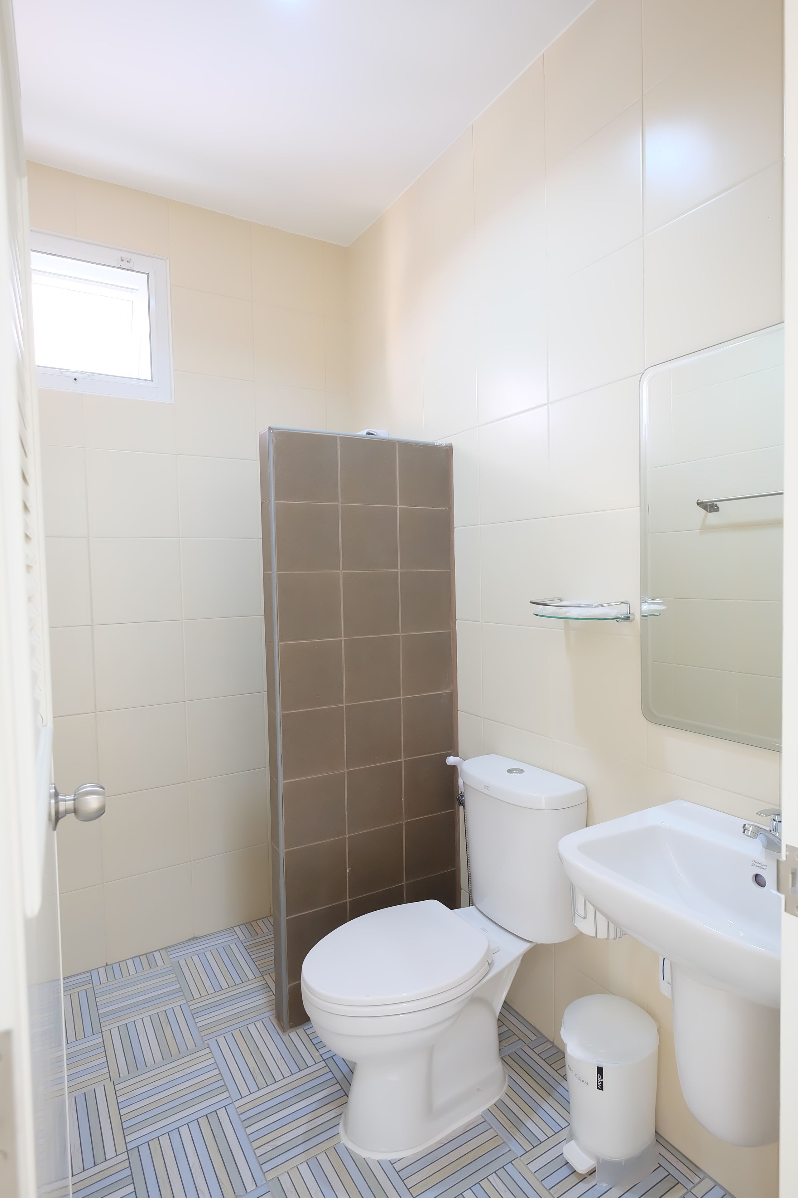A bathroom with a toilet, sink, and shower.