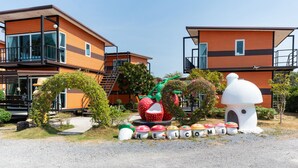 A modern building with a wooden facade, large windows, and a balcony. - OYO 755 Rattana Resort (Ko Lanta)
