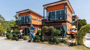 A modern two-story building with large windows, a balcony, and a welcome sign. - OYO 755 Rattana Resort (Ko Lanta)