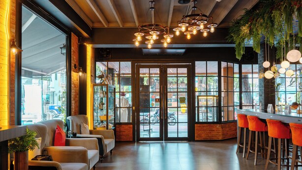 Ein modernes Interieur mit Bar, Sitzgelegenheiten und großen Fenstern.