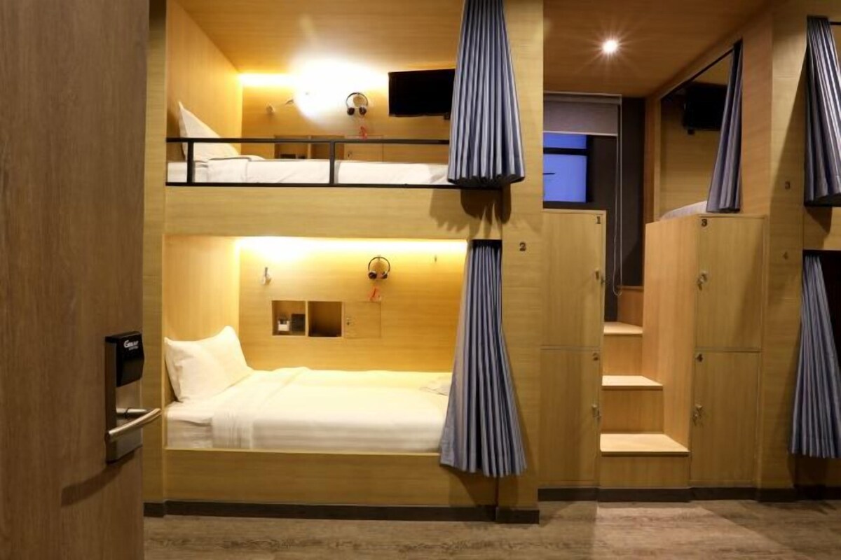 A room with bunk beds, a TV, and a desk with a computer.