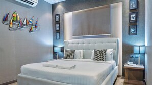 Ein modernes Hotelzimmer mit einem großen Bett, einem Nachttisch mit Lampe und einer Wand-Klimaanlage.