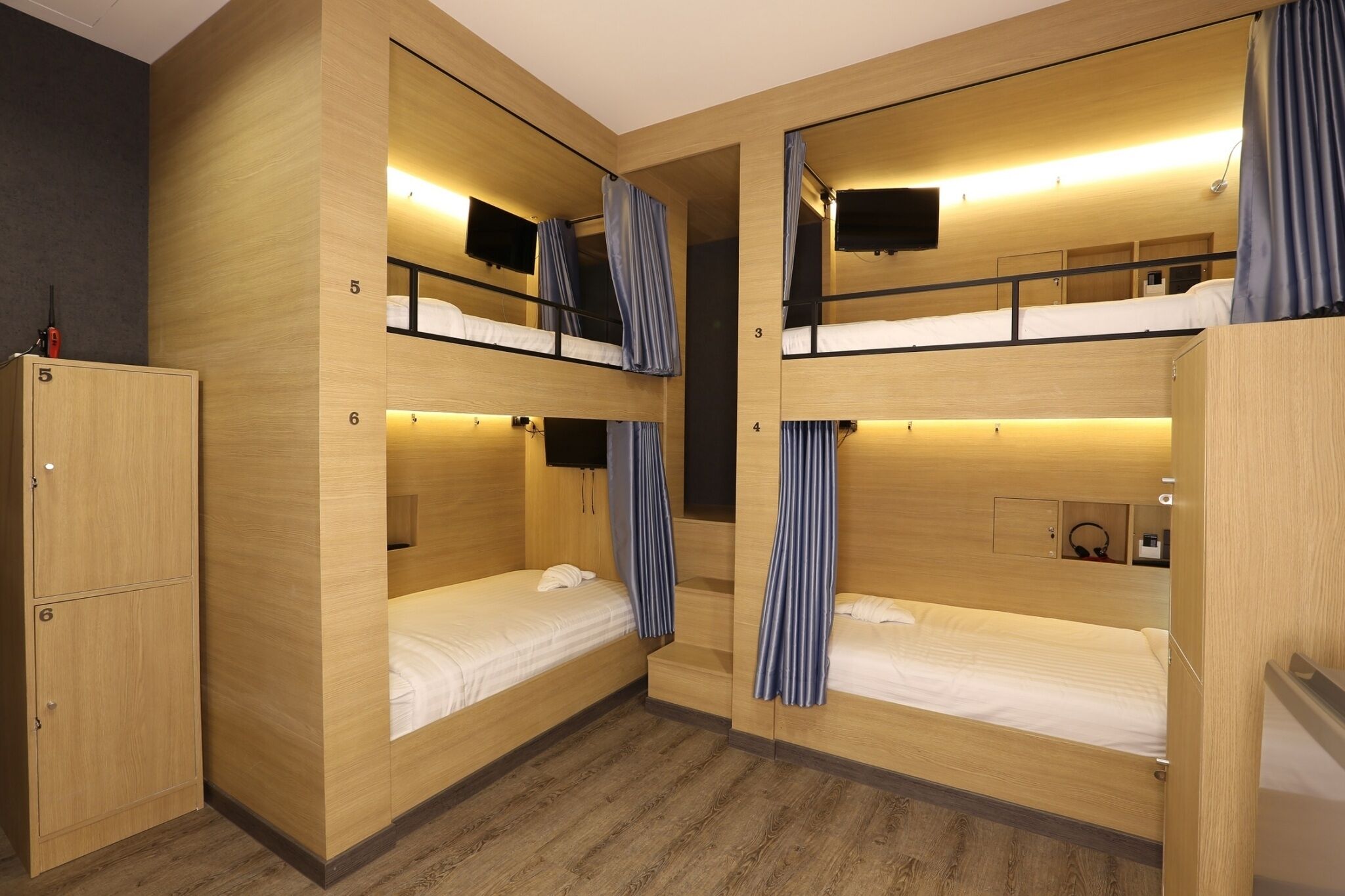 A bunk room with wooden walls, a wardrobe, and a TV.