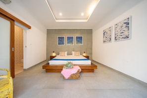 A modern bedroom with a large bed, bedside lamps, and artwork on the walls.
