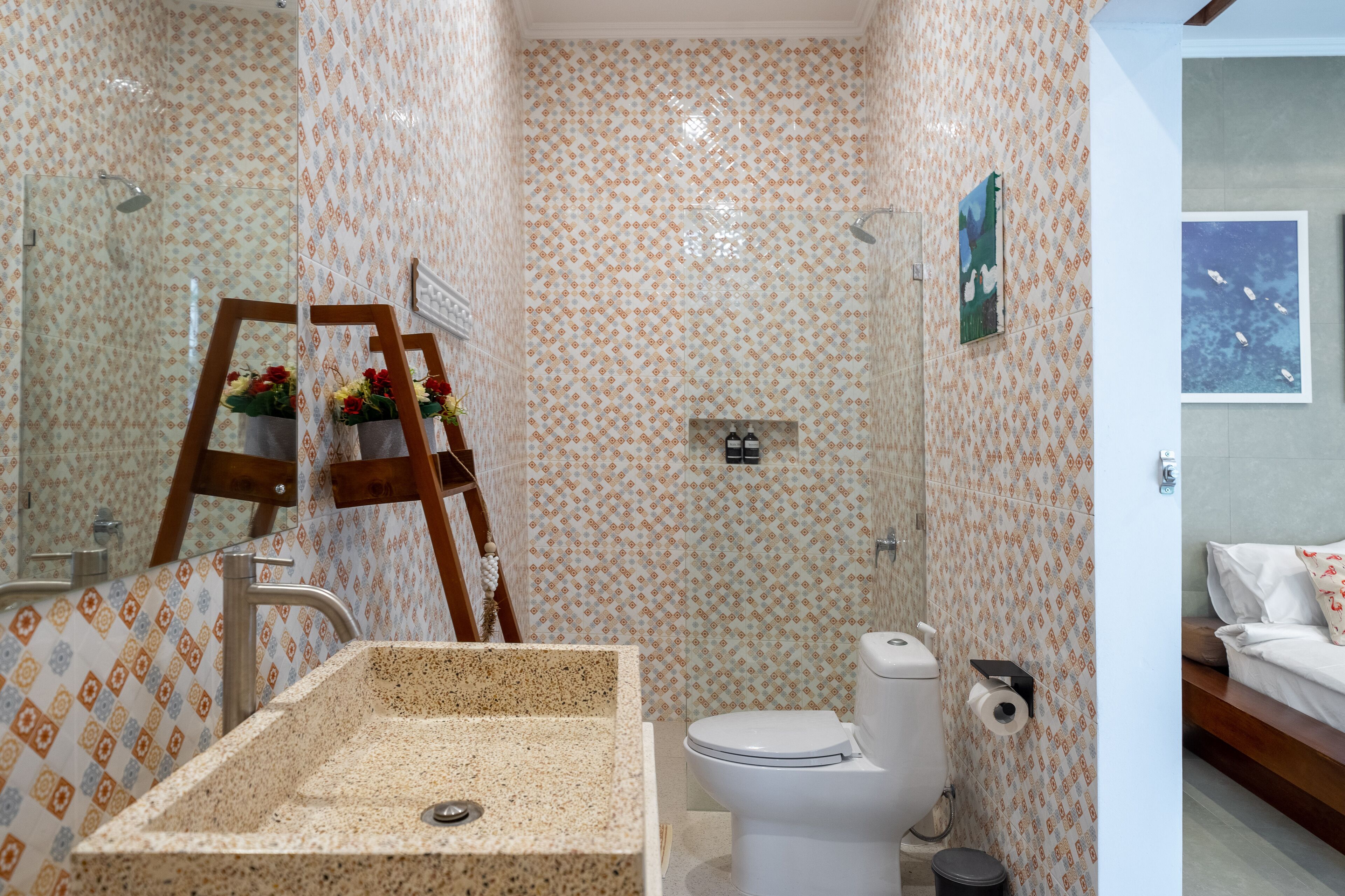 Un baño con azulejos estampados, un lavabo, inodoro y ducha.