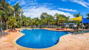 Alberca al aire libre y camastros