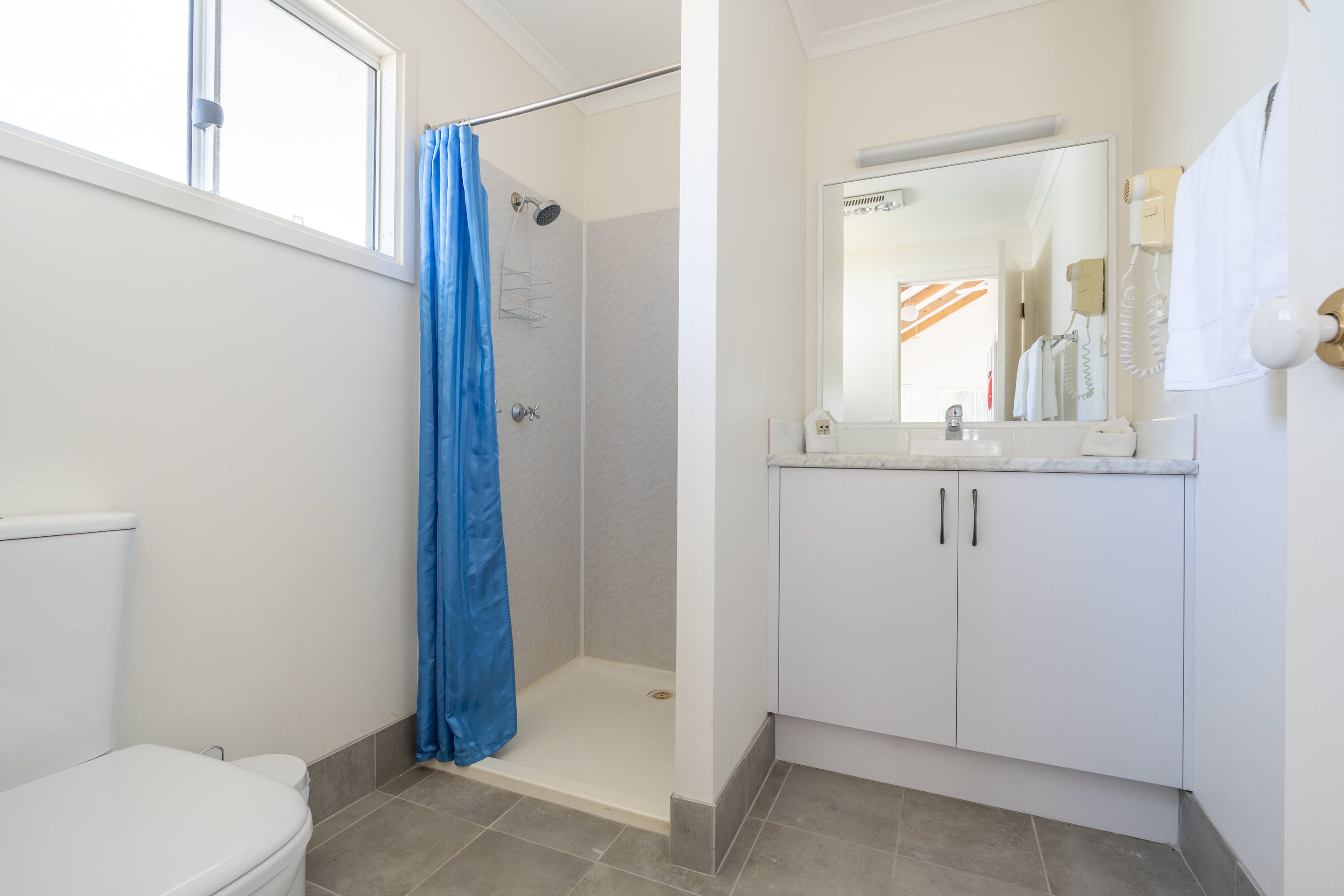 A bathroom with a shower, toilet, and sink.