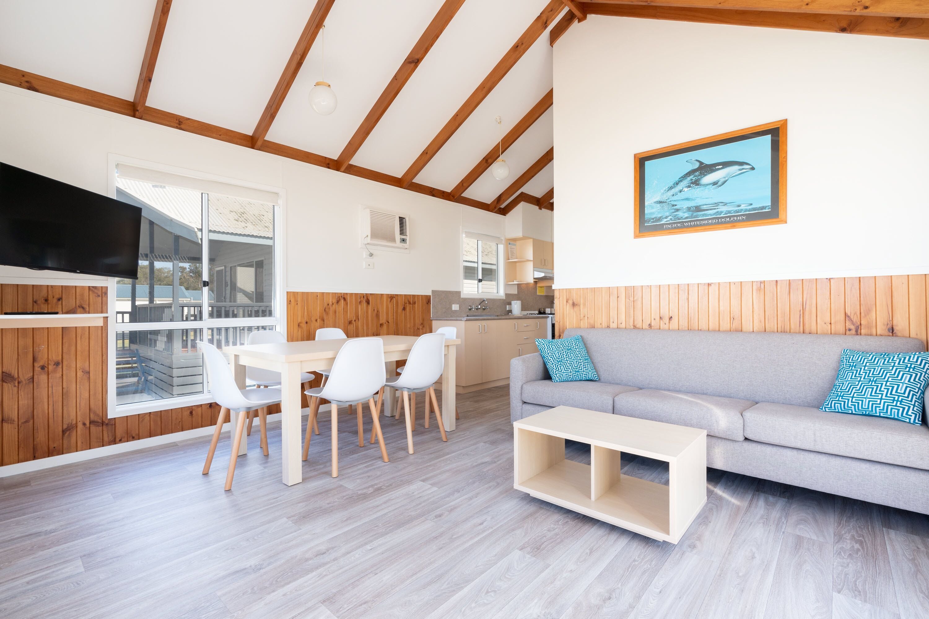 A modern interior with a dining area, a sofa, and a kitchen.