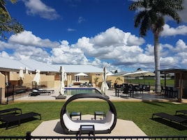 Una piscina al aire libre, sillones reclinables de piscina