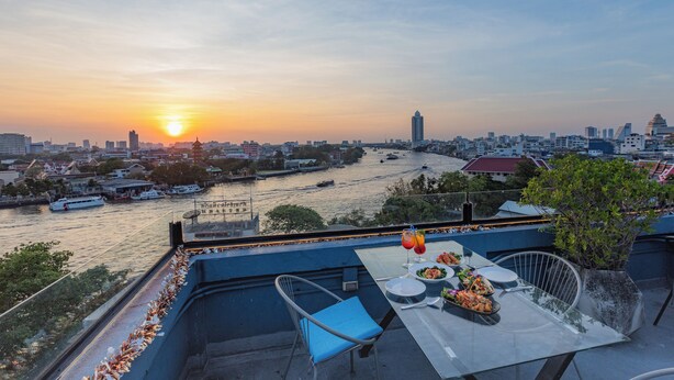 Mesa para dos con vista a la ciudad, sobre un río y edificios.