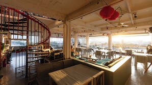 Un restaurante con una escalera de caracol, zonas de estar y vistas a la ciudad.