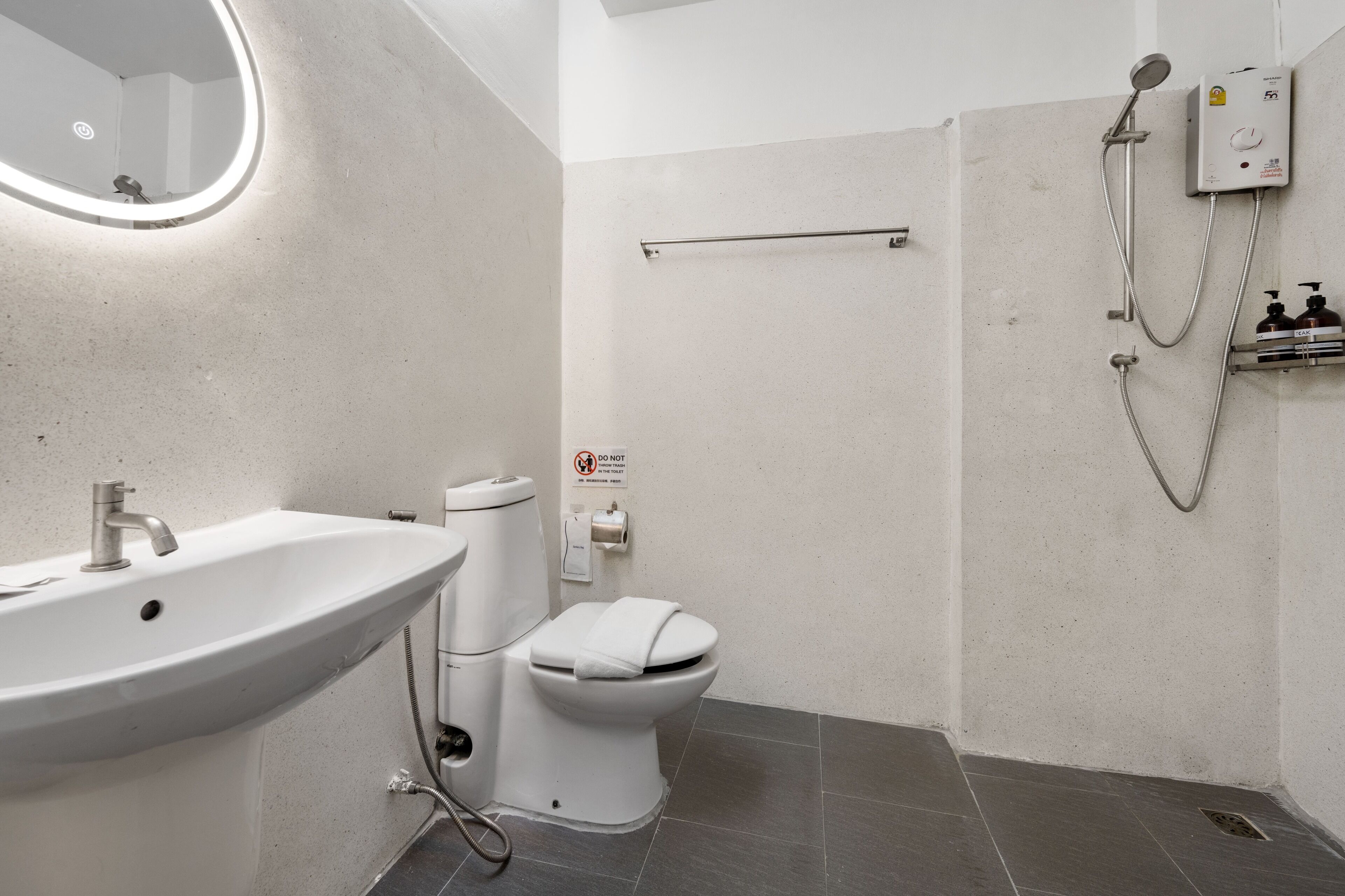 Un baño moderno con lavamanos, inodoro y ducha.