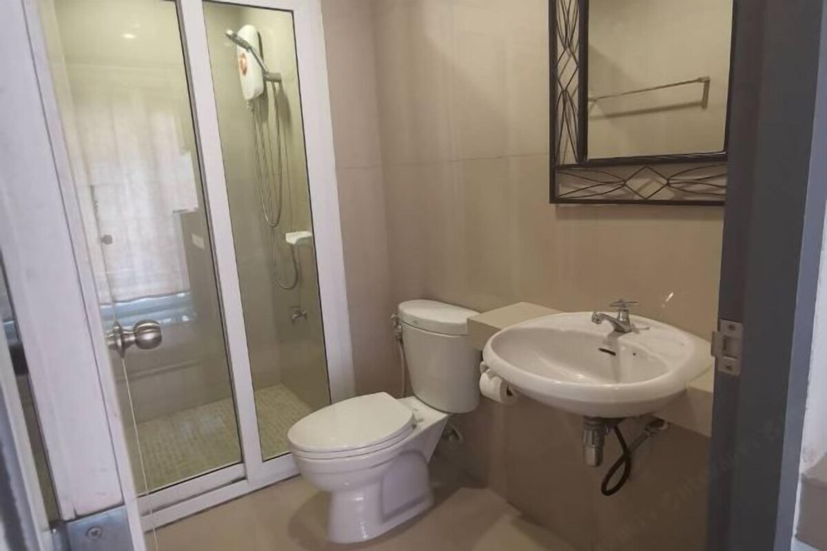 Un baño con inodoro, lavabo y cabina de ducha de vidrio.