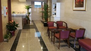A hotel lobby with a reception desk, seating area, and a large window. - Hotel Quartz Shin Osaka (Osaka)