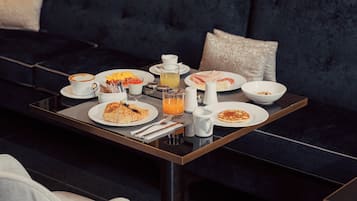 A breakfast table with plates of food, a coffee cup, and a juice glass.