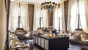 A modern hotel lobby with a central bar area, seating arrangements, and large windows with curtains. - The Venice Times Hotel, Vignette Collection by IHG (Venice)