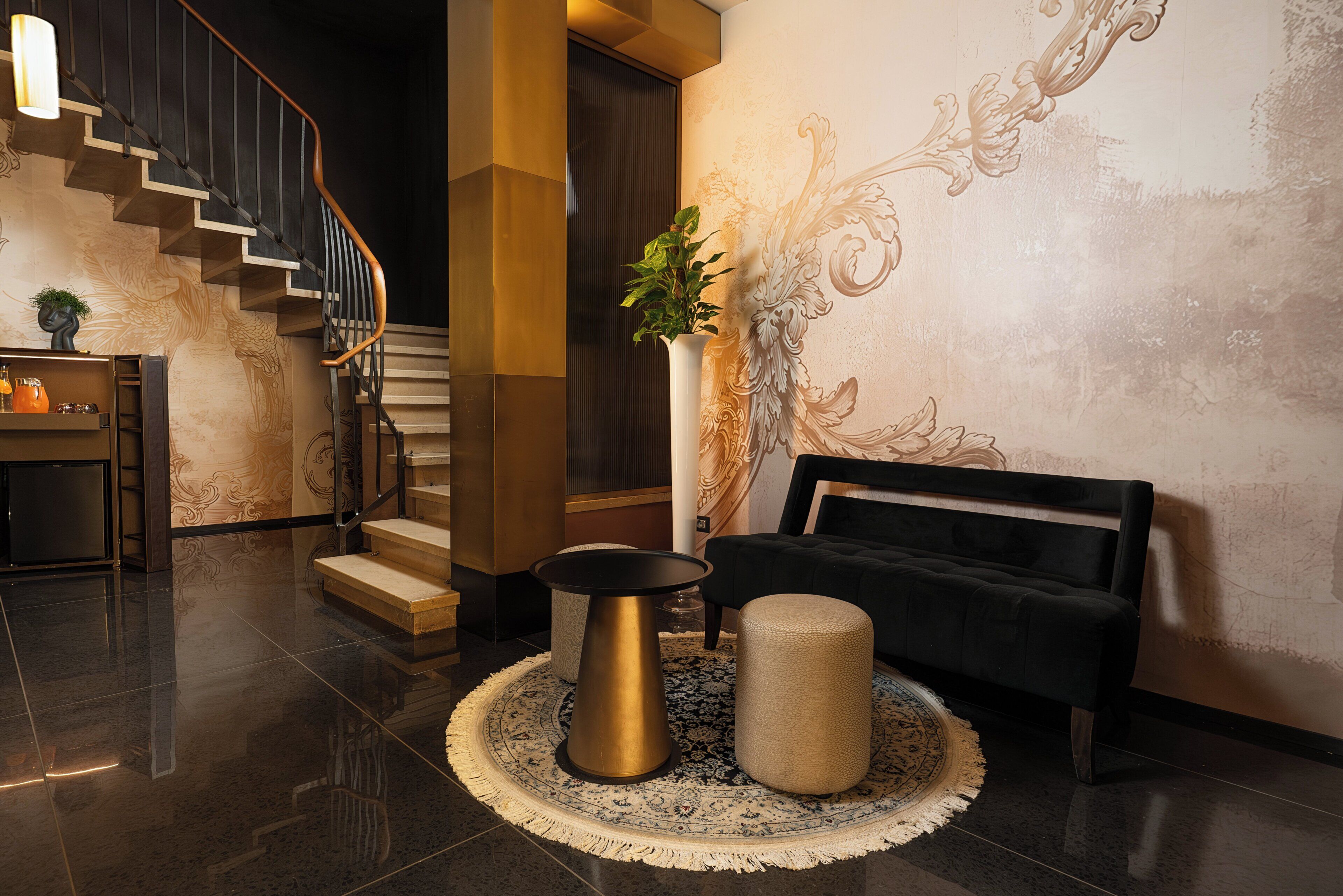 A modern interior with a staircase, a round coffee table, a sofa, and a decorative rug.