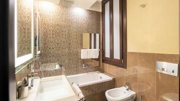 Un baño con bañera, lavabo, bidé e inodoro.