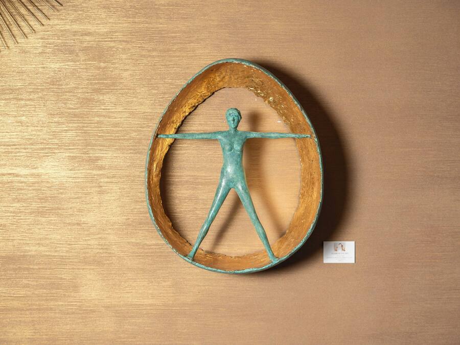 Escultura de madeira com uma figura dentro de um círculo.