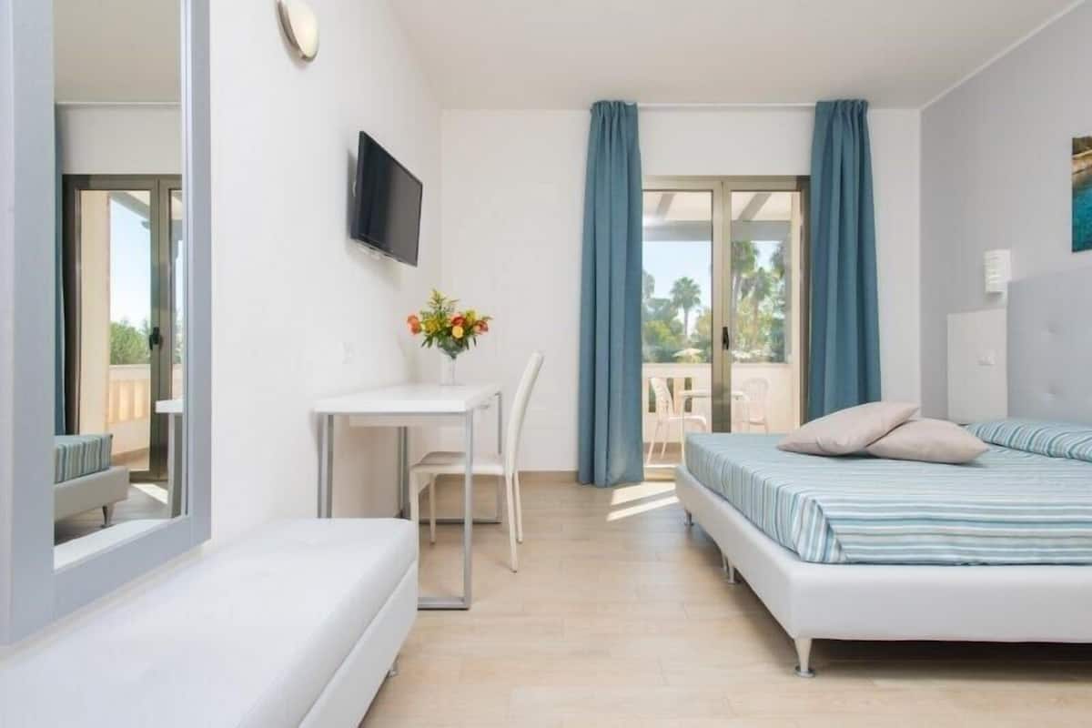 A bedroom with a bed, a desk, and a chair.